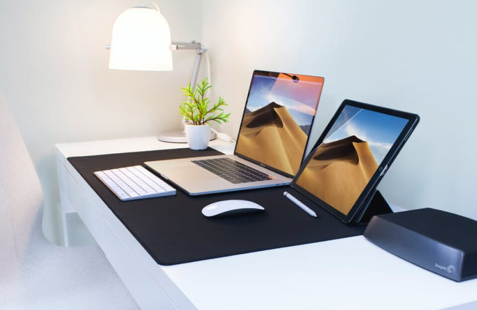 Setup de tecnologia moderno com notebook e tablet para análise da Curadoria Prime.