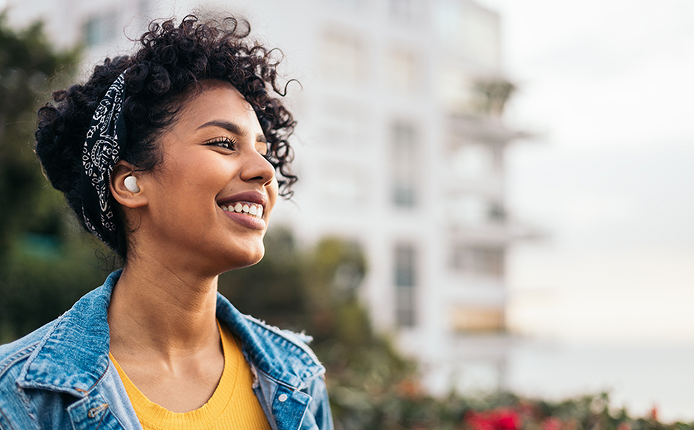 JBL Wave Buds 2 encaixado na orelha mostrando haste longa característica e encaixe seguro para treinos