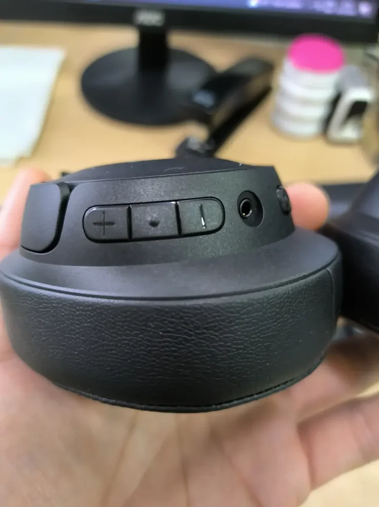 Detalhe dos botões físicos de volume e reprodução e da entrada P2 de 3,5 mm do JBL Tune 720BT